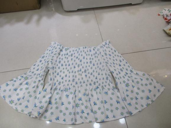 Blusa blanca con estampado azul y vuelo acampanado