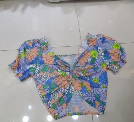 Blusa azul con nudo frontal y flores tropicales