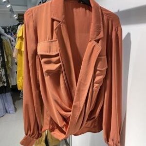 Blusa marrón con caída fluida y bolsillos frontales