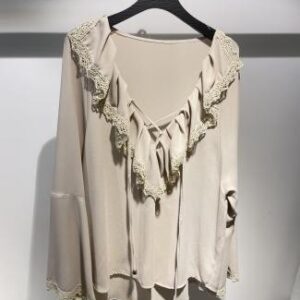 Blusa beige con escote en “V” y volantes en el cuello
