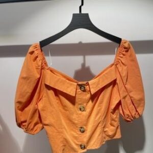 Blusa naranja corta con escote en “V” y botones grandes