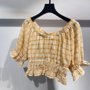 Blusa amarilla con hombros descubiertos y fruncido en la cintura