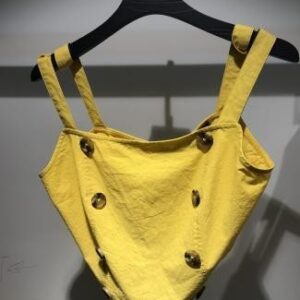 Blusa amarilla con tiras y botones decorativos