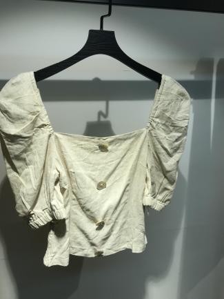 Blusa blanca con mangas abullonadas y botones frontales