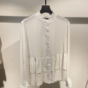 Blusa blanca con cuello alto y botones frontales